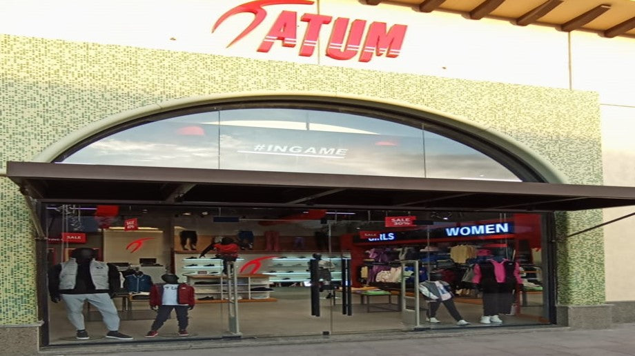 a group of people standing in front of a store front with a sign above it that says, saturn