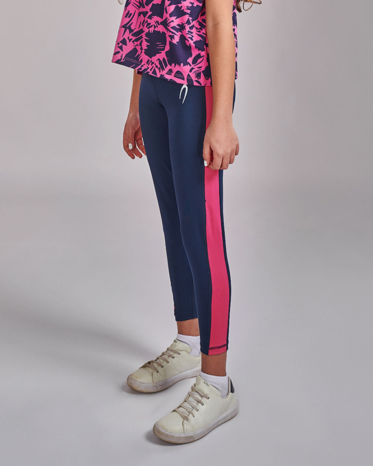 Photo by 𝗔𝗧𝗨𝗠 SPORTSWEAR ® on December 20, 2022. May be an image of 1 girl wears navy/pink leggings with atum emblem.