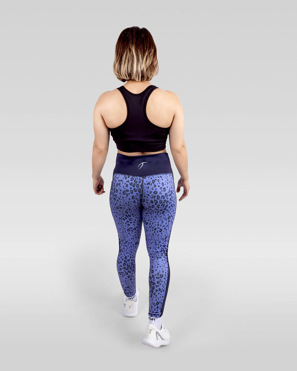 Photo by 𝗔𝗧𝗨𝗠 SPORTSWEAR ® on December 20, 2022. May be an image of 1 woman wears printed purple/navy floral leggings, and black sports bra with white shoes.