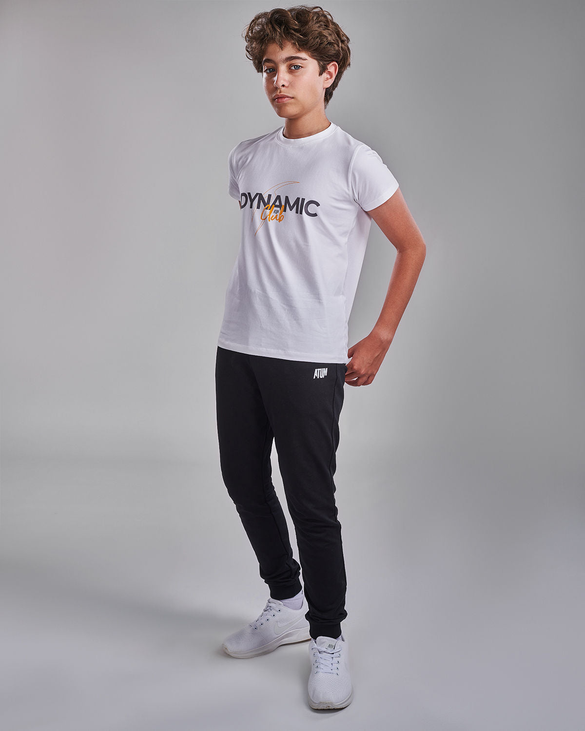 Photo by 𝗔𝗧𝗨𝗠 SPORTSWEAR ® on May 22, 2022. May be an image of 1 boy wears a white t-shirt with a text ''Dynamic club",and a sweatpants.