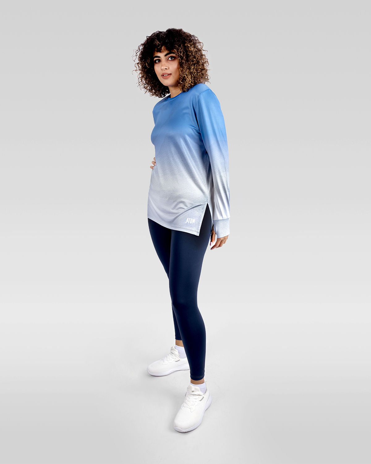 Photo by ð—”ð—§ð—¨ð— SPORTSWEAR Â® on December 20, 2022. May be an image of 1 woman wears blue gradient t-shirt, navy leggings, and white shoes.