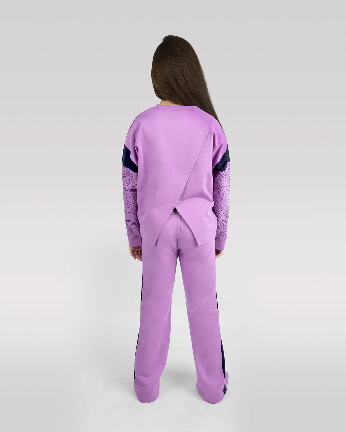 Photo by ð—”ð—§ð—¨ð— SPORTSWEAR Â® on December 20, 2022. May be an image of 1 girl wears violet sweatshirt with atum emblem, and violet wide leg pants.