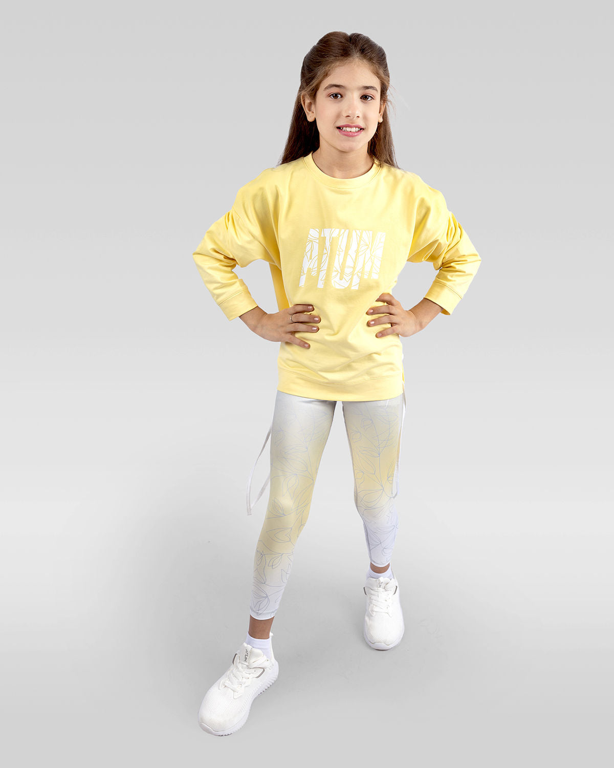 Photo by ð—”ð—§ð—¨ð— SPORTSWEAR Â® on December 20, 2022. May be an image of 1 girl wears yellow sweatshirt, yellow leggings and white shoes with printed Atum.