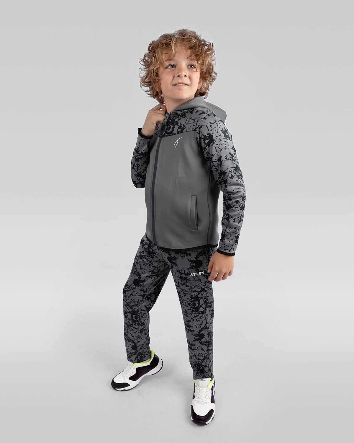 Photo by ð—”ð—§ð—¨ð— SPORTSWEAR Â® on December 20, 2022. May be an image of 1 boy wearing a gray printed sweatpants, gray jacket, and white shoes.